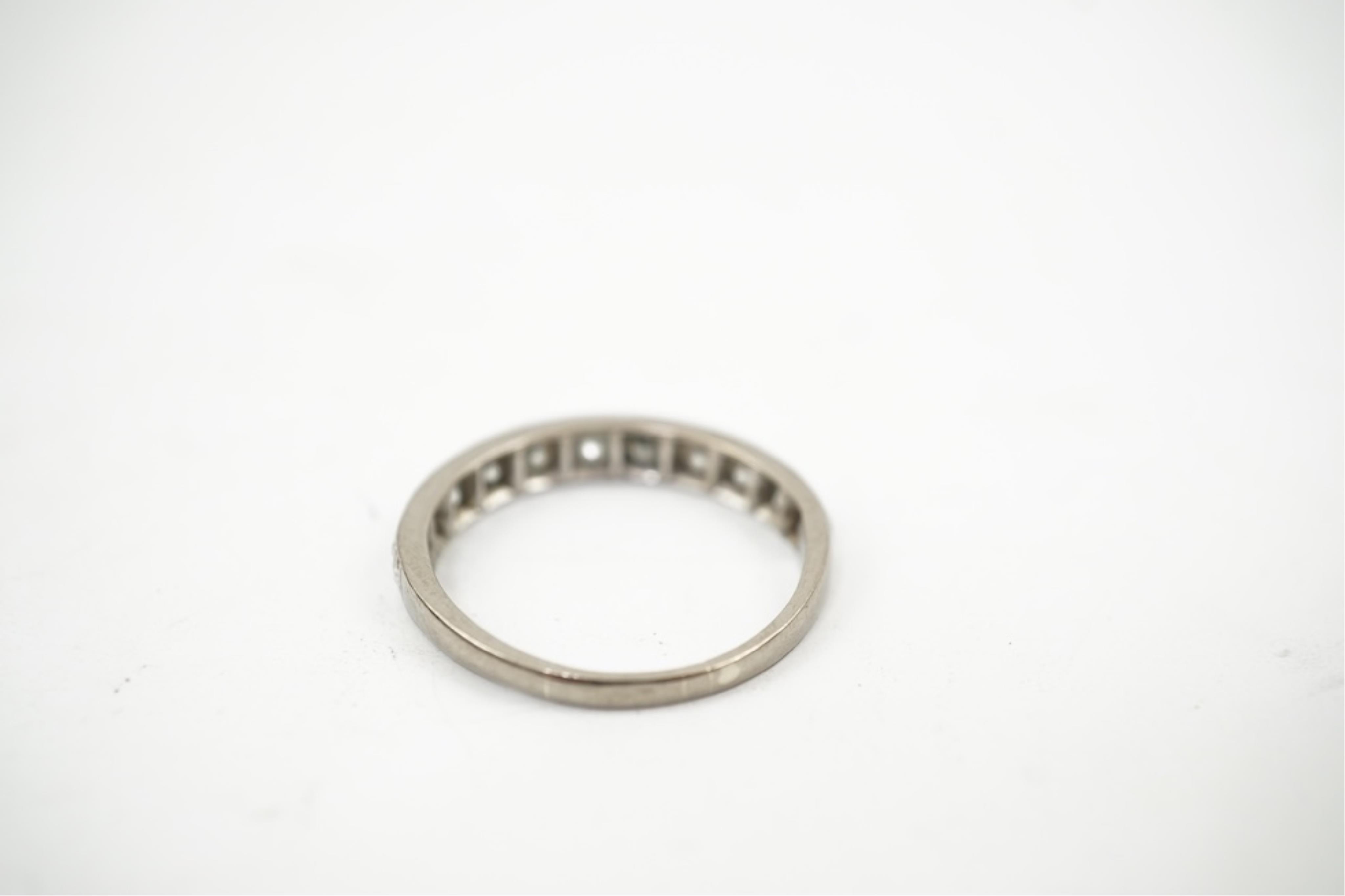 An 18ct white metal and graduated eleven stone diamond set half eternity ring, size P/Q. gross weight 3 grams.